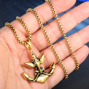 Detailed view of a vintage gold anchor pendant with nautical rope relief on a box chain