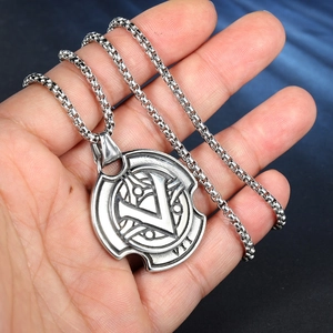 Gros plan du pendentif hache viking avec relief V et VII en finition argent mate
