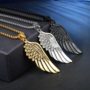 Pendentifs ailes vintage en or, argent et noir présentés sur un fond de velours