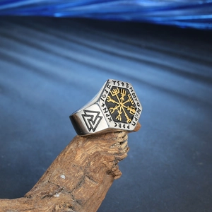 Makroaufnahme von Wikinger Vegvisir Ring mit Valknut Gravur auf einem Holzzweig