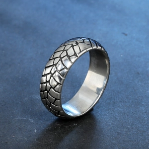 Men's stainless steel ring with creative tire-tread pattern shown at a 45-degree angle