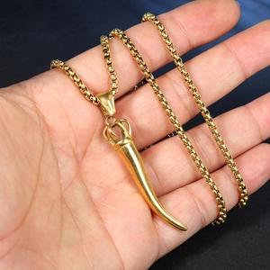 Detail of golden Italian horn pendant with crown charm on a square box chain necklace