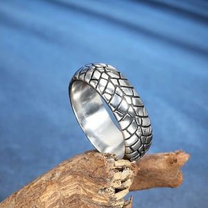 Men's vintage stainless steel ring featuring unique tire scale texture on wood stand