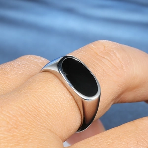 Macro view of a classic stainless steel signet ring with oval black onyx inlay detail
