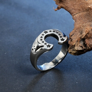 Vintage stainless steel horseshoe ring with engraved stars on a textured background