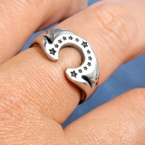 Macro shot of vintage silver stainless steel U-shaped ring with engraved star patterns