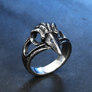 Vue macro d'une bague crâne de corbeau vintage avec finition argentée et détails gothiques