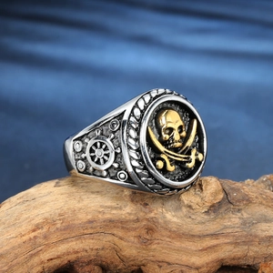 Men's punk pirate skull ring in stainless steel with golden cutlasses on wooden base