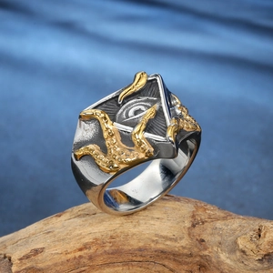 Vintage silver Eye of Horus ring with gold octopus accents on a rustic wooden base