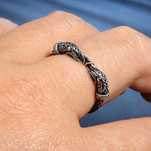Bague vintage argentée à tête de dragon et nœud celtique portée au doigt