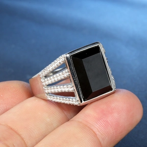 Detailed view of men's silver ring with rectangular black onyx and hollow side design