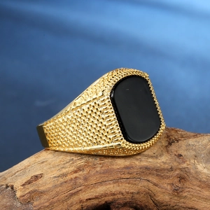 Mens vintage golden stainless steel signet ring with black stone on driftwood