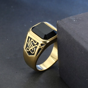 Macro shot of men's vintage gold steel ring with rectangular black onyx stone inlay