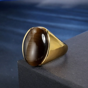 Nahaufnahme eines ovalen braunen Katzenaugensteins in poliertem goldenem Edelstahlring