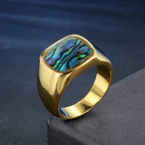 Macro detail of men's gold signet ring featuring iridescent abalone shell inlay