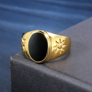 Close-up of a vintage gold steel ring with black oval stone and sun relief on leather