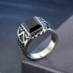 Detailed macro view of men's punk stainless steel ring featuring a square black onyx stone