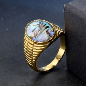 Detailed close-up of gold-plated anxiety ring featuring an iridescent abalone shell inlay