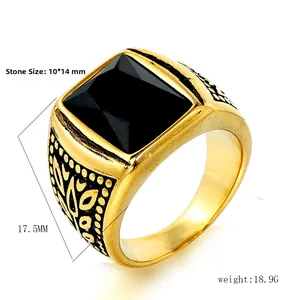 Detalle de anillo vintage dorado con gran gema negra cuadrada y grabados ornamentales