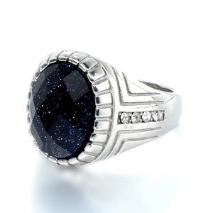 Macro shot of oval blue sandstone ring with silver band and side stone accents