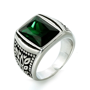 Detalle de anillo vintage de hombre con piedra verde esmeralda y motivos de hojas