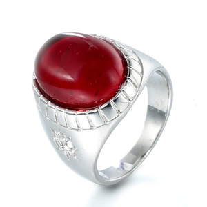 Macro detail of men's stainless steel ring featuring an oval red gemstone and star carvings
