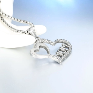 Macro detail of silver heart pendant with MOM engraving and intricate grain texture