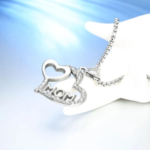 Macro shot of silver heart pendant with MOM engraving and cut-out on stainless steel chain