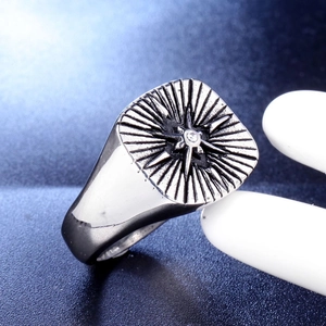 Macro detail of men's vintage compass ring with sunburst relief and center zircon crystal