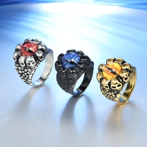 Detailed macro of gothic skull rings with dragon scales and vibrant colored gemstones
