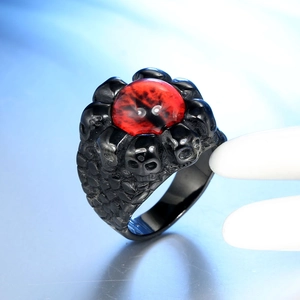 Macro view of gothic skull ring with a large red stone and detailed punk engravings