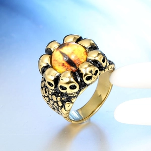 Macro detail of gothic skull ring featuring a yellow dragon eye stone and golden finish