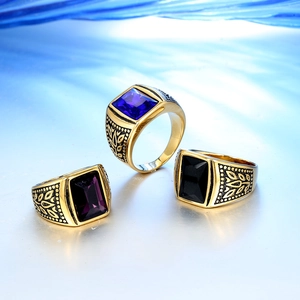 Detalle de anillos vintage para hombre en oro con gemas rectangulares azules, púrpuras y negras