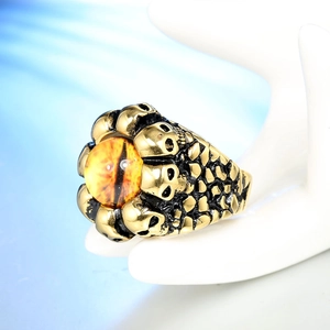 Detail of a punk skull ring with a yellow eye stone on a ceramic hand display stand