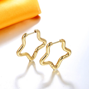 Créoles dorées en forme d'étoile en acier inoxydable avec design ondulé sur fond blanc