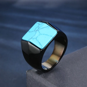 Close-up of black geometric stainless steel ring with a square turquoise stone inlay