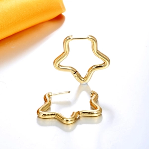 Vue macro de boucles d'oreilles créoles étoiles dorées avec finition polie