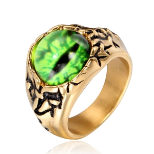 Makroaufnahme von Punk-Titanstahlring mit grünem Auge und goldener Klauentextur