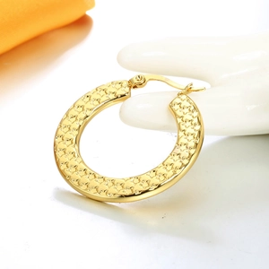 Macro shot of 18K gold star embossed hoop earrings with a secure snap closure