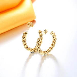 Detail view of twisted rope texture golden C-shaped hoop earrings with butterfly backs