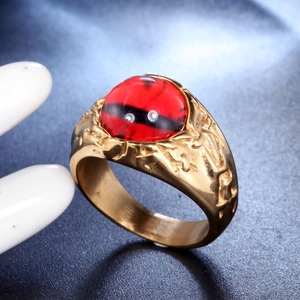 Makro-Detail des Herren-Goldstahlrings mit rotem Augen-Edelstein und Textur