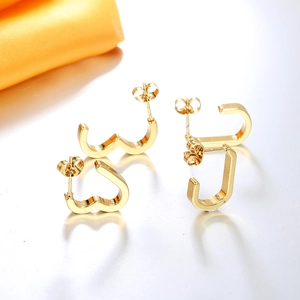 Detail of 18K gold geometric earrings featuring wavy heart and U-shaped designs