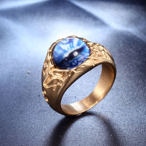 Makroaufnahme eines goldenen Edelstahlrings im Punk-Stil mit einem blauen Evil Eye Stein