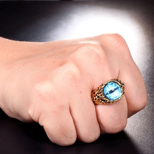 Nahaufnahme eines Vintage-Punk-Rings aus Gold-Edelstahl mit blauem Evil-Eye am Finger