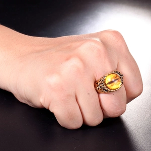 Detailansicht eines goldenen Vintage-Stahlrings mit Drachenauge-Bernstein am Finger