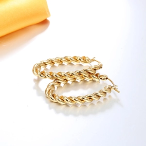 Gros plan de boucles d'oreilles en U plaquées or 18 carats avec texture torsadée