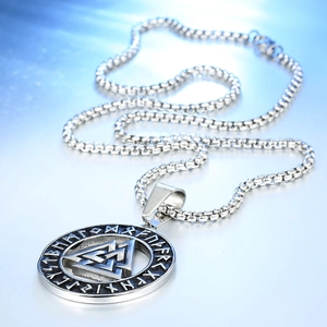 Retro stainless steel Viking cross necklace with Valknut pendant on blue metal surface