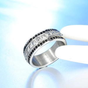 Macro shot of stainless steel ring with pyramid studs and double rows of black zircons