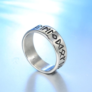 Macro detail of Nordic Viking runes engraved on a matte stainless steel band ring