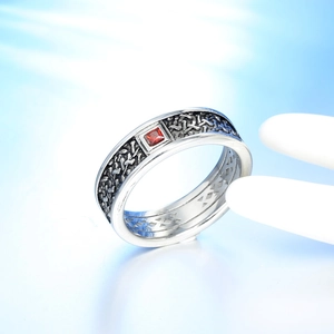 Vintage silver ring with engraved texture and square red gemstone on display stand